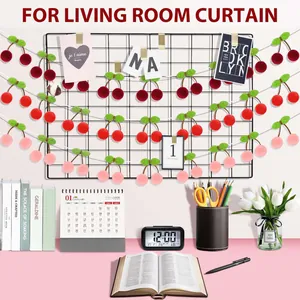 Pink and red plush cherry garland hanging on a wall grid for romantic room decoration
