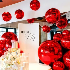 Metallic red 4D sphere foil balloons in various sizes for a 50th birthday party scene