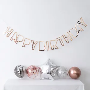 Detail of rose gold hollow Happy Birthday banner with elegant decorative balloons