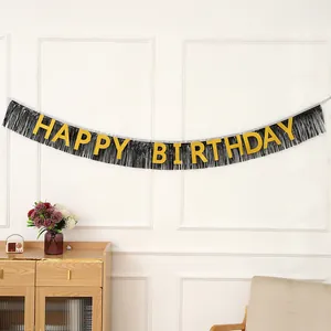 Détail de la bannière Happy Birthday avec lettres dorées sur fond de franges noires