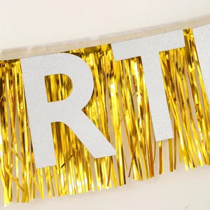 Détail de lettres pailletées argentées et franges dorées pour décoration de fête