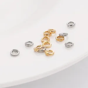 Détail de connecteurs de bijoux dorés et argentés posés sur une assiette en céramique blanche