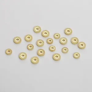 Macro-opname van gouden tandwielvormige tussenkralen met textuur voor DIY-sieraden