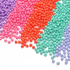 Vue à plat de perles de rocaille colorées de 5 mm en violet, rose, orange, vert et bleu