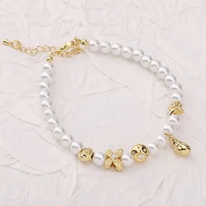 Elegantes weißes Perlenarmband mit goldenem Delfinanhänger und Abstandsperlen