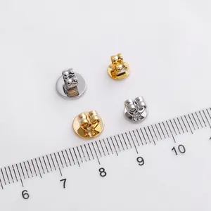 Poussettes de boucles d'oreilles dorées et argentées avec base disque sur règle