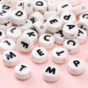 Macro shot of white ceramic alphabet beads with black letters for DIY jewelry crafting
