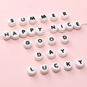 DIY ceramic alphabet beads for jewelry making with black capital letters on white surface