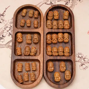 Carved wooden Buddhist zen figurines in a presentation tray with traditional motifs