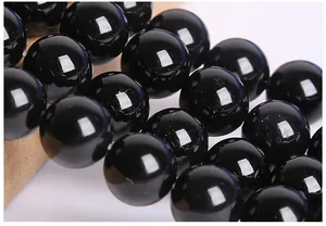 Macro shot of polished black agate round beads with smooth mirror-like finish for DIY jewelry