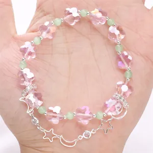 Dettaglio del bracciale con perline di cristallo rosa e ciondoli a stella e luna