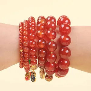 Red agate bead bracelet with golden lucky charms and lion pendants in various bead sizes