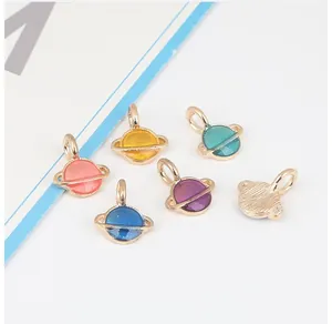 Makroaufnahme bunter Emaille-Planetenanhänger für DIY-Schmuck mit Goldmetallbeschichtung