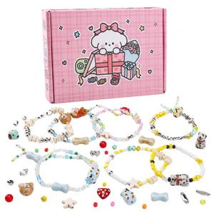 Detail van DIY kralenarmbandenset met dierenhangers en roze geschenkdoosverpakking
