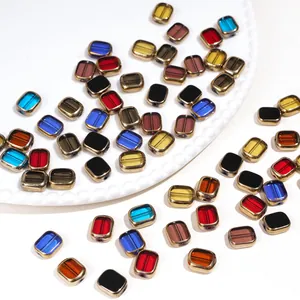 Macro shot of colorful oval glass beads with gold-rimmed borders for DIY jewelry making