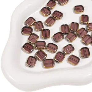 Macro view of transparent purple glass oval beads with gold-plated edges for DIY jewelry