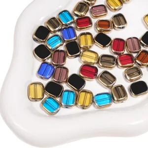 Macro view of colorful square glass beads with gold metal frames for DIY jewelry