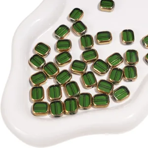 Close-up of green rectangular glass beads with golden metal edges for DIY jewelry making