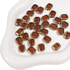 Close-up of amber glass oval beads with gold-plated edges for DIY jewelry making