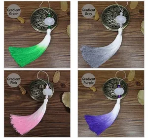Détail de pendentifs lotus sculptés avec glands en soie dégradée en quatre couleurs