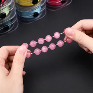 Detailed view of pink cat eye beads on an elastic string showing texture and stretch