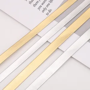 Makro-Detail von metallischen Gold- und Silber-PU-Lederstreifen mit feiner Narbung