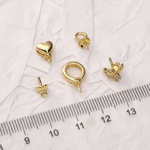 Flat lay of 14K gold plated heart pendants and jewelry findings with scale ruler