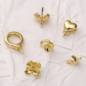 Detailed view of 14K gold-plated copper earring posts with heart and clover base settings
