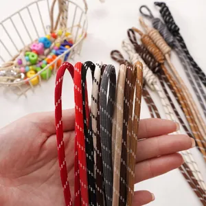 Handheld view of multi-color woven polyester cords with white dots for DIY jewelry making