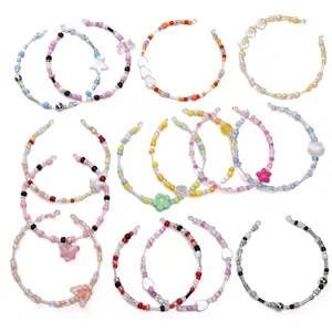 Lot de 16 bracelets de perles DIY colorés avec divers pendentifs sur fond blanc éclatant