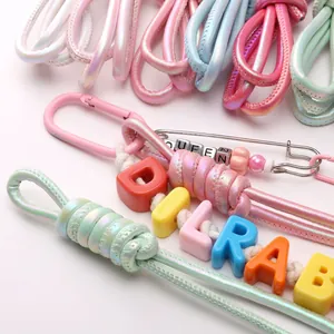 Detail of macaron braided cord with metallic clasp and Queen letter beads for DIY jewelry