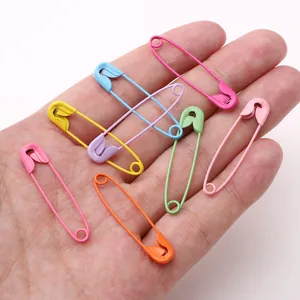 Colorful matte painted iron safety pins in hand showing various vibrant DIY colors