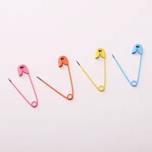 Detail showing pink orange yellow and blue painted metal safety pins on white background