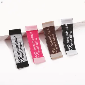 Close-up of handmade with love woven fabric clothing labels in four various colors