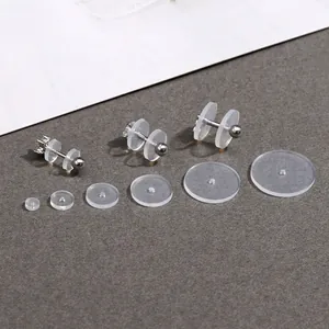 Set of transparent silicone earring backs and earring lifters in various sizes on grey background