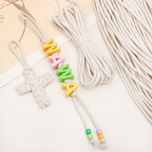 Detail van 3mm wit katoenen touw met handgeweven kruis en kleurrijke MAMA kralenhangers