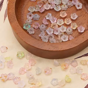 Macro detail of 6x3mm acrylic flower beads with gold leaf for DIY jewelry making