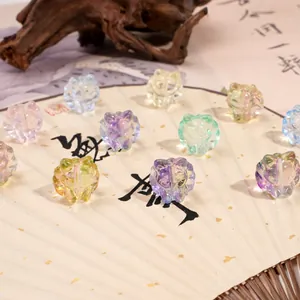 Translucent cat-shaped glass beads for DIY jewelry displayed on a traditional paper fan