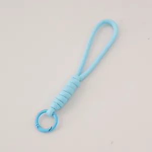 Portachiavi in paracord intrecciato blu cielo con clip a molla tonda su pelle chiara