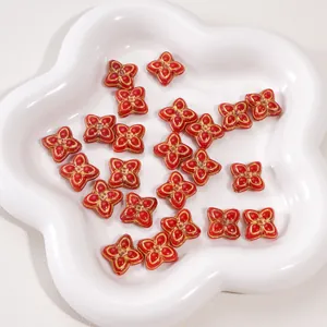 Macro view of red clover charms with golden edges for DIY jewelry and bracelets