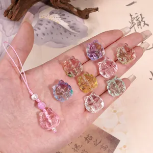 Cat-shaped glass beads in various colors placed on a hand for DIY jewelry making