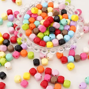 Macro detail of colorful cube acrylic beads in a glass bowl for DIY jewelry making