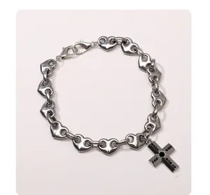 Silver stainless steel heart link bracelet featuring a gothic black stone cross pendant