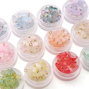 Vue détaillée de pendentifs papillons en verre coloré dans des pots pour bijoux DIY