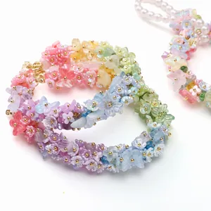 Detailed macro view of colorful gradient resin flower charms with golden metal beads