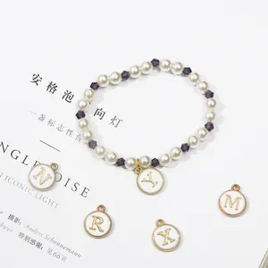 Détail d'un bracelet en perles DIY avec perles de cristal violettes et breloques émaillées