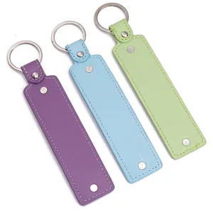 Detailed view of handmade leather keychains in purple, light blue, and green colors