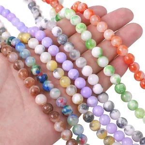 Perle tonde sintetiche lisce e colorate tenute in mano per gioielli fai da te e artigianato