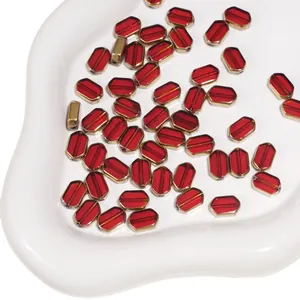 Macro detail of red octagonal glass beads with gold plated edges for DIY jewelry making