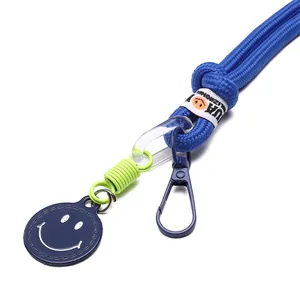 Blue nylon woven keychain with green spring connector and smiley face charm